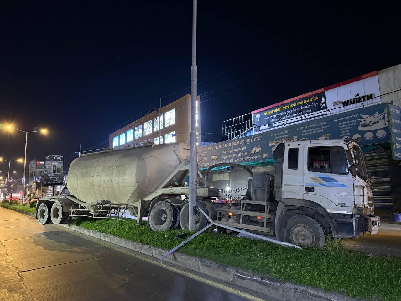 រថយន្តដឹកស៊ីម៉ង់ត៍បើកបុកបង្គោលភ្លើងបាក់ទ្រេតលើសួនច្បារផ្លូវភ្នំពេញ-ហាណូយ